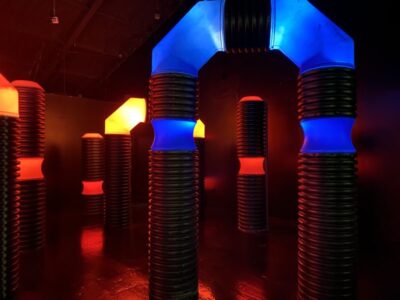 Indoor laser tag arena at Jellystone Park™ with glowing obstacles and play structures