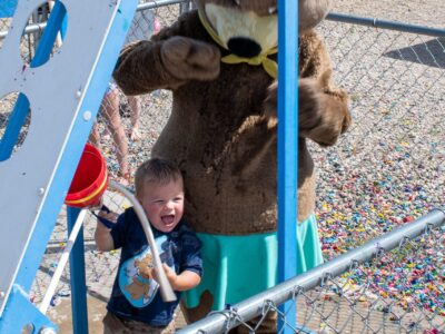 Child playing water game with Jellystone Park™ character during Water Wars activity