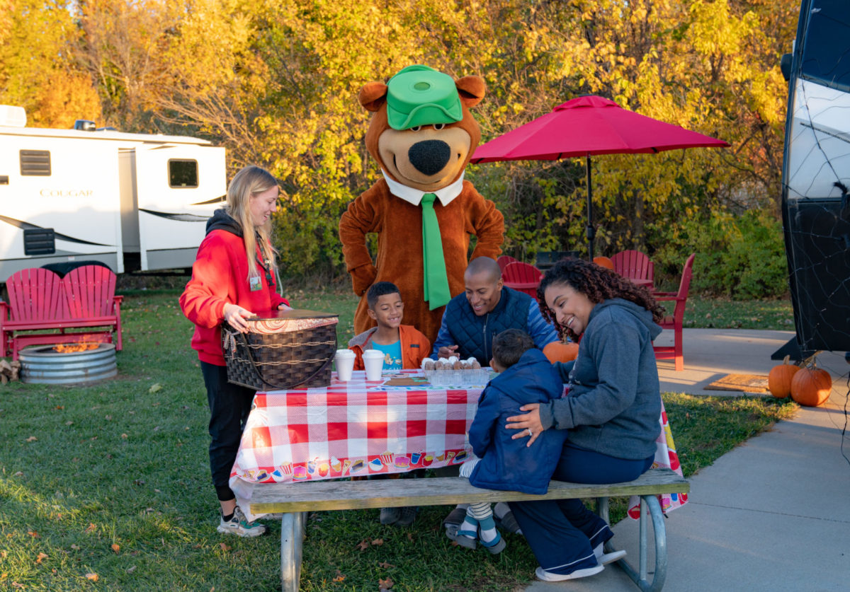 Yogi Bear visiting a family at their campsite picnic table at Jellystone Park South Haven
